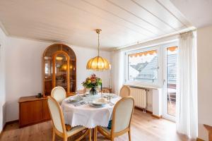 a dining room with a table with chairs and a chandelier at Munich Hideaway in Karlsfeld