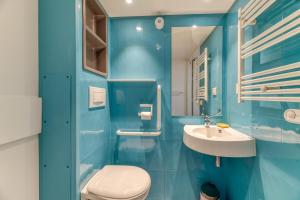 a blue bathroom with a toilet and a sink at Logis Les Forges in Arvillard +125 photos
