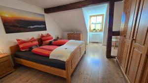a bedroom with a wooden bed with red pillows at Fewo Gipfelstürmer mit Königscard in Nesselwang