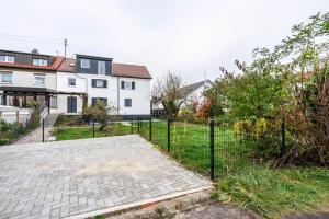 a fence in front of a yard with houses at Munich Hideaway in Karlsfeld