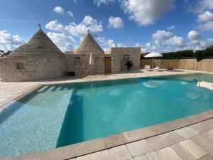 a villa with a swimming pool and a house at Trullo Mandorlo in Martina Franca