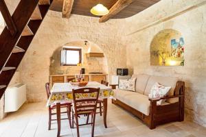 a living room with a table and a couch at Trullo Mandorlo in Martina Franca