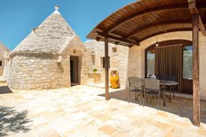 an outdoor patio with a table and a stone building at Trullo Mandorlo in Martina Franca