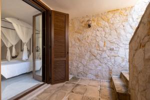 a bedroom with a stone wall and a doorway at Cala D'Aspide in Santa Caterina di Nardò +228 photos