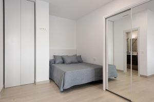a bedroom with a bed and a mirror at Apartamentos Sealmar Moliere in Málaga
