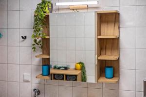 a kitchen with wooden shelves on a tiled wall at Fewo Gipfelstürmer mit Königscard in Nesselwang +24 photos