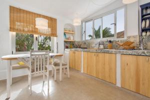 a kitchen with wooden cabinets and a table and chairs at El Refugio de Churchill in Máguez