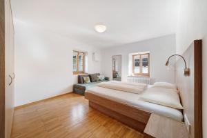 a white bedroom with a large bed and a couch at Appartement Wielander A Ost in Laces