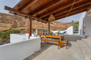 a patio with a wooden table and a bench at El Refugio de Churchill in Máguez