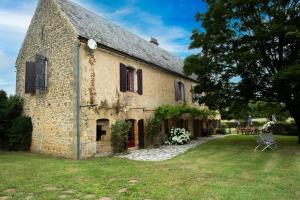 an old stone building with a grass yard at Le Bel Prat in Domme