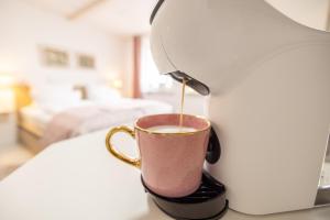 a coffee maker pouring coffee into a coffee cup at Apartment Wasenberg in Willingshausen