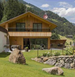 a large wooden house with a grill in the yard at Chalet de Ultimis in Ultimo