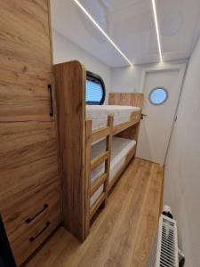 a small room with two bunk beds and a window at Führerscheinfreies mobiles Hausboot in Rechlin