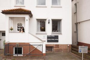 a dog sitting in the window of a white house at Apartment Wasenberg in Willingshausen