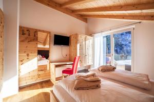a bedroom with a bed and a desk and a window at Chalet de Ultimis in Ultimo
