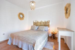 a bedroom with a bed and a table in it at Sunny Home in Lajares +17 photos
