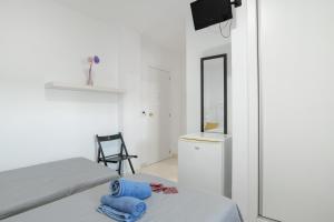 a bedroom with a bed and a mirror and a chair at Hostal Avenida in Conil de la Frontera