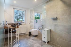 a bathroom with a shower and a toilet and a sink at Ferienwohnung Manthei in Kluis +16 photos