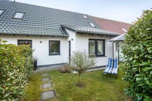 a white house with a blue chair in the yard at Ferienwohnung Manthei in Kluis