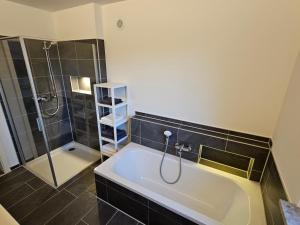 a bathroom with a bath tub and a shower at Ferienwohnung Auszeit in Solnhofen +15 photos