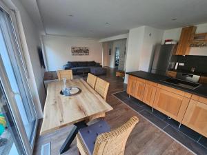 a kitchen and living room with a wooden table at Ferienwohnung Auszeit in Solnhofen
