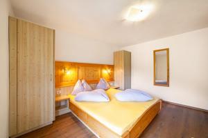 a bedroom with a large yellow bed with pillows at Fichtenhof Wohnung Enzian in Tarces