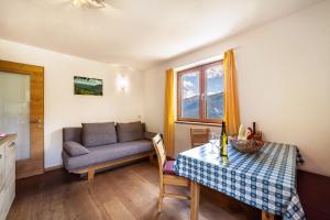 a living room with a table and a couch at Fichtenhof Wohnung Enzian in Tarces