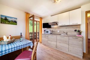 a kitchen with a table and a sink and a microwave at Fichtenhof Wohnung Enzian in Tarces +6 photos