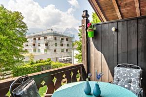 a table on a balcony with a view of a building at Johannas Alm in Garmisch-Partenkirchen