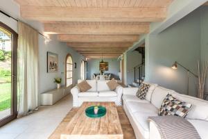 a living room with white furniture and a wooden ceiling at Chalet Azzurro in Trequanda +36 photos