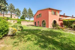 a house on a hill with a green yard at Chalet Azzurro in Trequanda