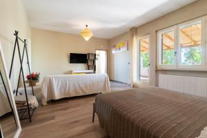 a bedroom with a bed and a table and a tv at A Look Salento in Castrignano del Capo