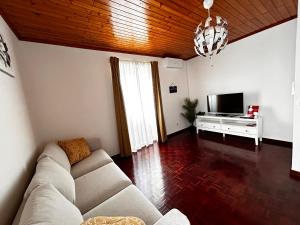 a living room with a couch and a television at Ocidente House 2 in Santa Cruz das Flores