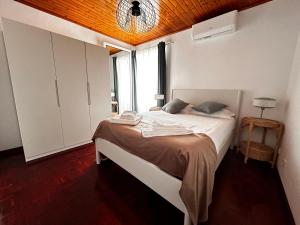 a bedroom with a bed and a large window at Ocidente House 2 in Santa Cruz das Flores