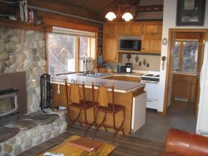 a kitchen with a stove and a stone fireplace at Rye Creek Lodge in Darby