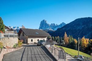 a house with a car parked in a driveway at Apt Lara Ruveda 2 in Ortisei