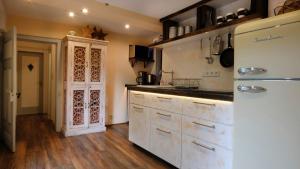 a kitchen with a white refrigerator and wooden floors at Haus Auenland in Groß Felda