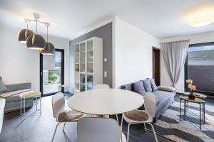 a living room with a couch and a table and chairs at Ferienhaus Sonnenwind Hainer See Eg in Neukieritzsch