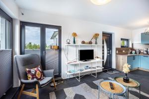 a living room with a tv and a kitchen at Ferienhaus Sonnenwind Hainer See Eg in Neukieritzsch