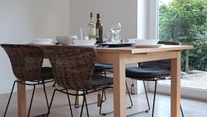 a dining room table with chairs and wine bottles at Ferienwohnung Birkenhof Alfsee in Rieste +7 photos