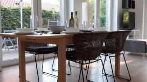 a wooden table with chairs and a dining room at Ferienwohnung Birkenhof Alfsee in Rieste