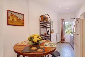 a kitchen with a table with a vase of flowers on it at G House Dolceacqua in Dolceacqua