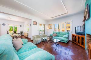 a living room with a blue couch and a tv at Villa Paca in Cala Ratjada