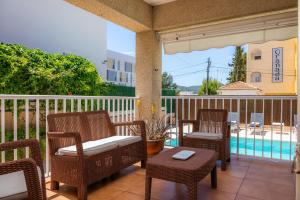 a patio with chairs and a table and a pool at Villa Paca in Cala Ratjada