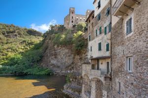 a castle sitting on top of a mountain next to a river at G House Dolceacqua in Dolceacqua