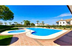 a large swimming pool in a yard with a house at Arcos golf Adosado 2 dormitorios in Arcos de la Frontera