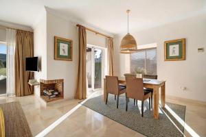 a dining room with a table and chairs and a tv at Arcos golf Adosado 2 dormitorios in Arcos de la Frontera
