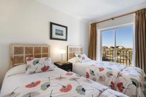 a bedroom with two beds and a window at Arcos golf Adosado 2 dormitorios in Arcos de la Frontera +32 photos