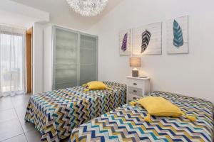 a bedroom with two twin beds and a chandelier at Villa Petala in Albufeira +13 photos