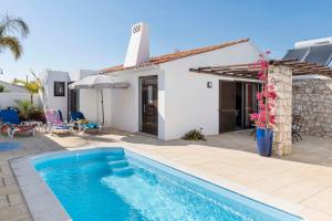 a villa with a swimming pool in front of a house at Villa Petala in Albufeira